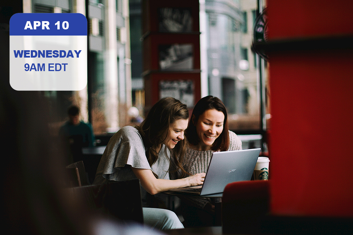 Two smiling women working on a laptop